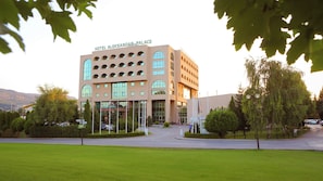 A hotel with a modern architectural design, featuring a prominent entrance with a glass facade and a sign reading 'HOTEL ALEXANDAR PALACE'. - Aleksander Palace (Skopje)
