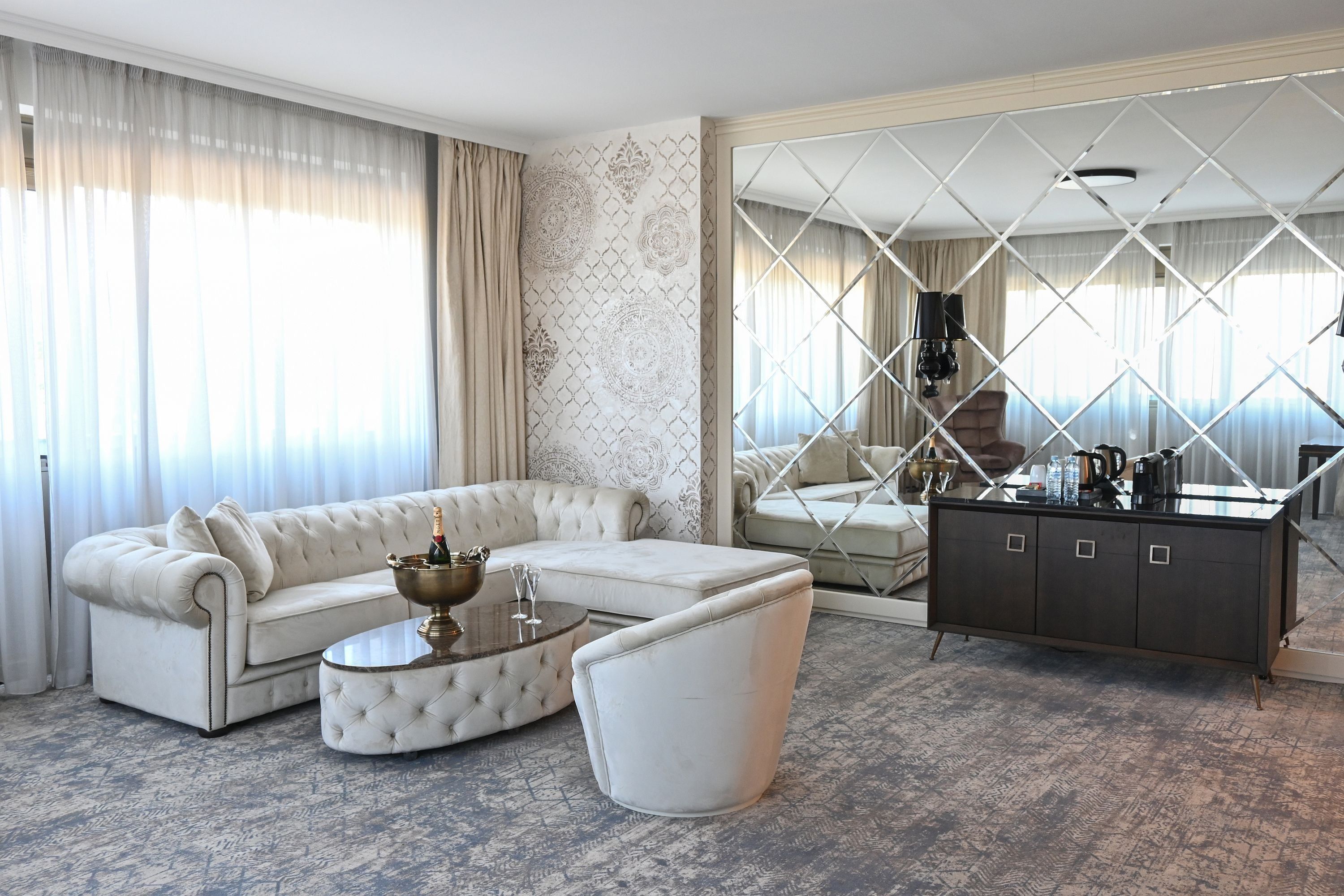 A modern living room with a sectional sofa, a round coffee table, and a dark-toned cabinet.