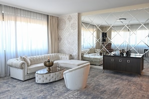 A modern living room with a sectional sofa, a round coffee table, and a dark-toned cabinet. - Aleksander Palace (Skopje)