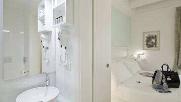A modern bathroom with a white sink, mirror, and built-in hairdryer.