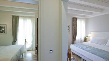 A bedroom with a bed, a bedside table, a lamp, and a window with curtains.