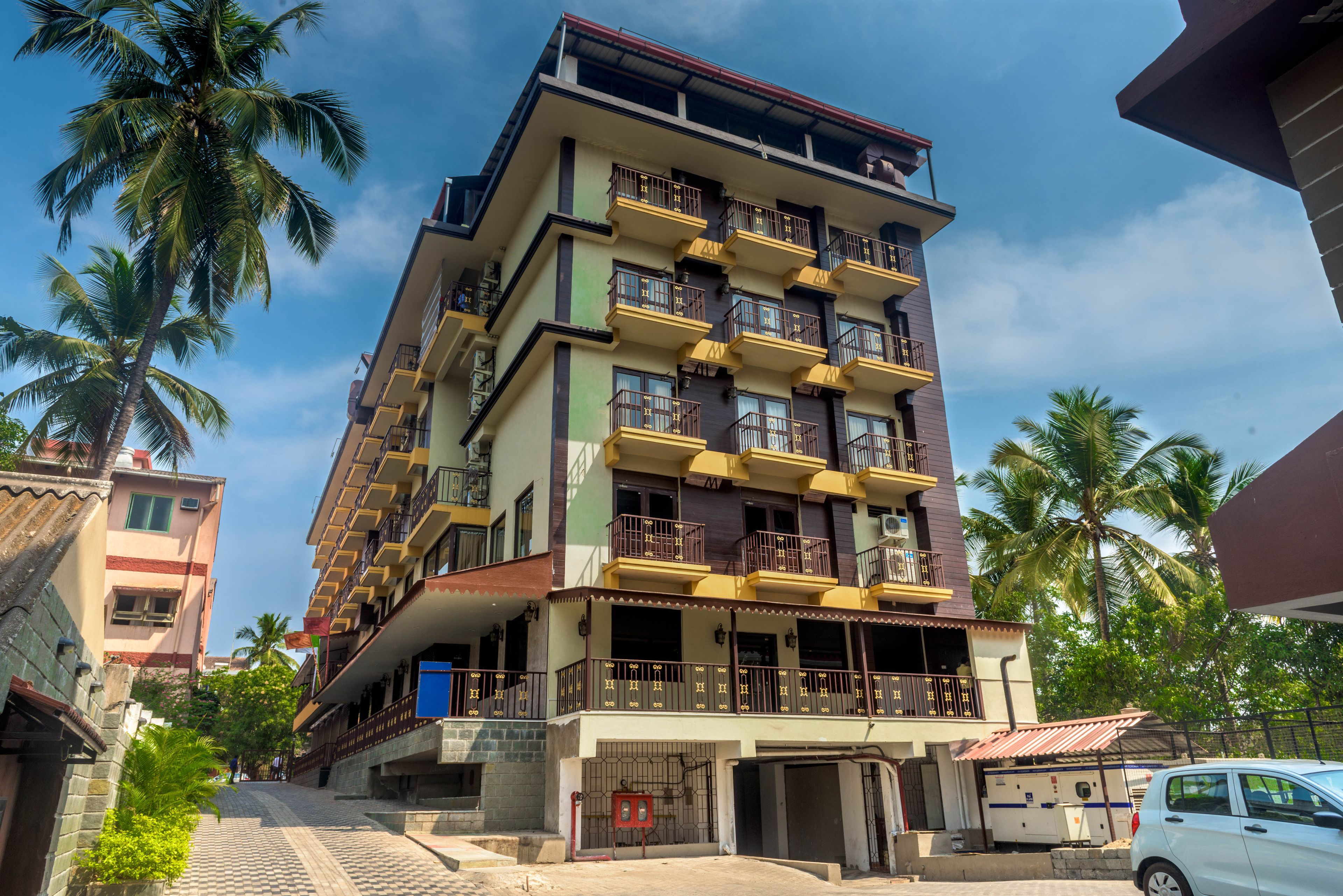 A multi-story residential building with balconies, a garage, and a gated entrance.