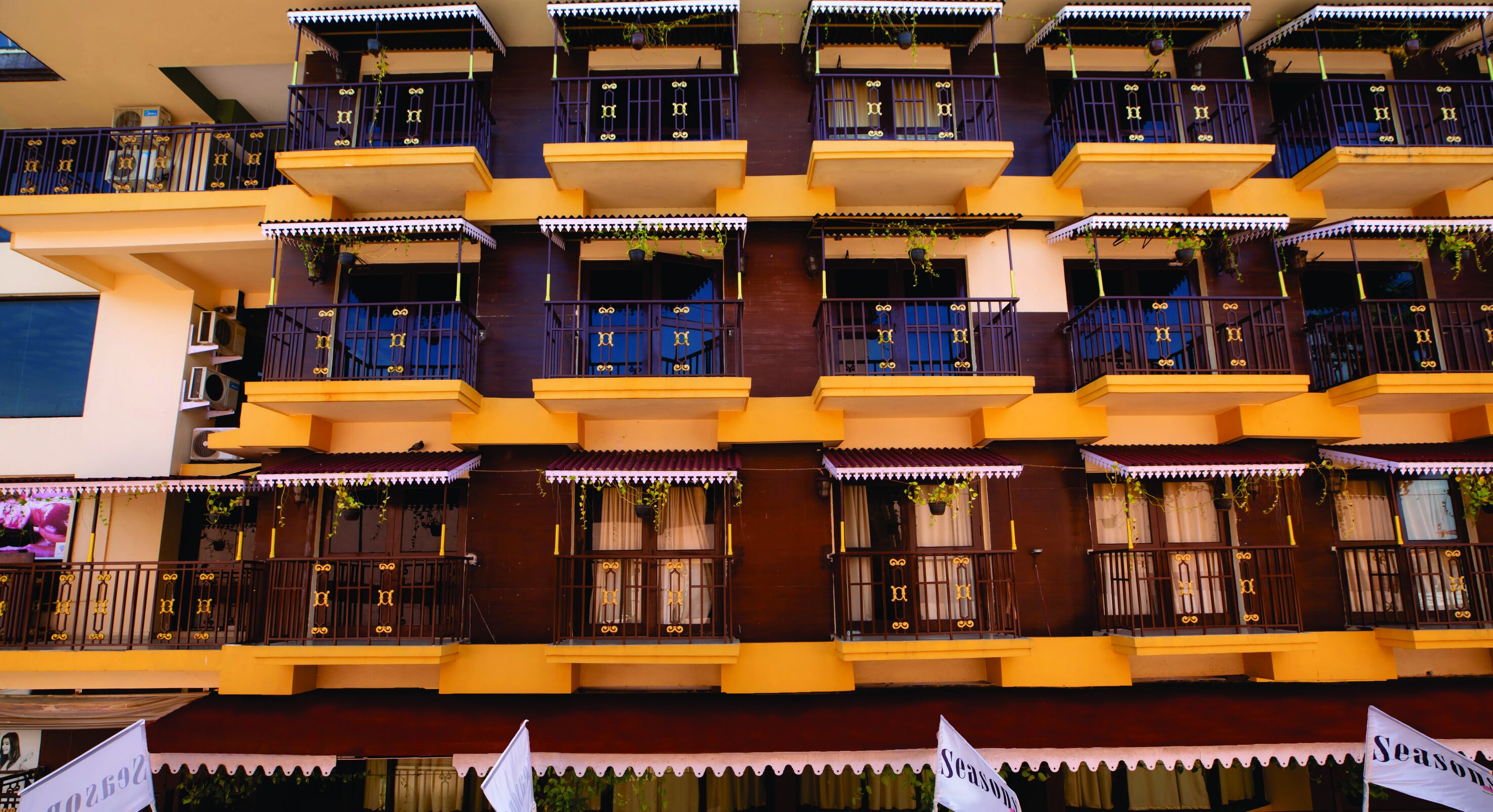 Un edificio de varios pisos con balcones, cada uno con un pequeño jardín.