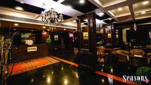 Un vestíbulo de hotel con mostrador de recepción, candelabros y decoración tradicional.