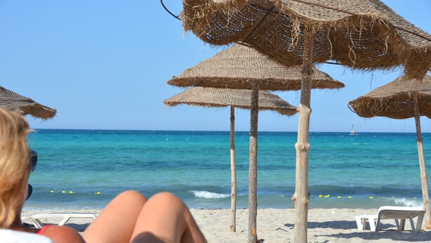 A beach with straw umbrellas and a clear view of the ocean. - Hotel Venice Beach - Families and Couples Only (Djerba Midun)