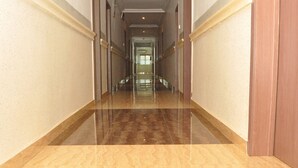 Un pasillo largo y estrecho con un piso brillante y paredes blancas.