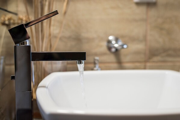 A modern bathroom with a sleek faucet and a white sink.