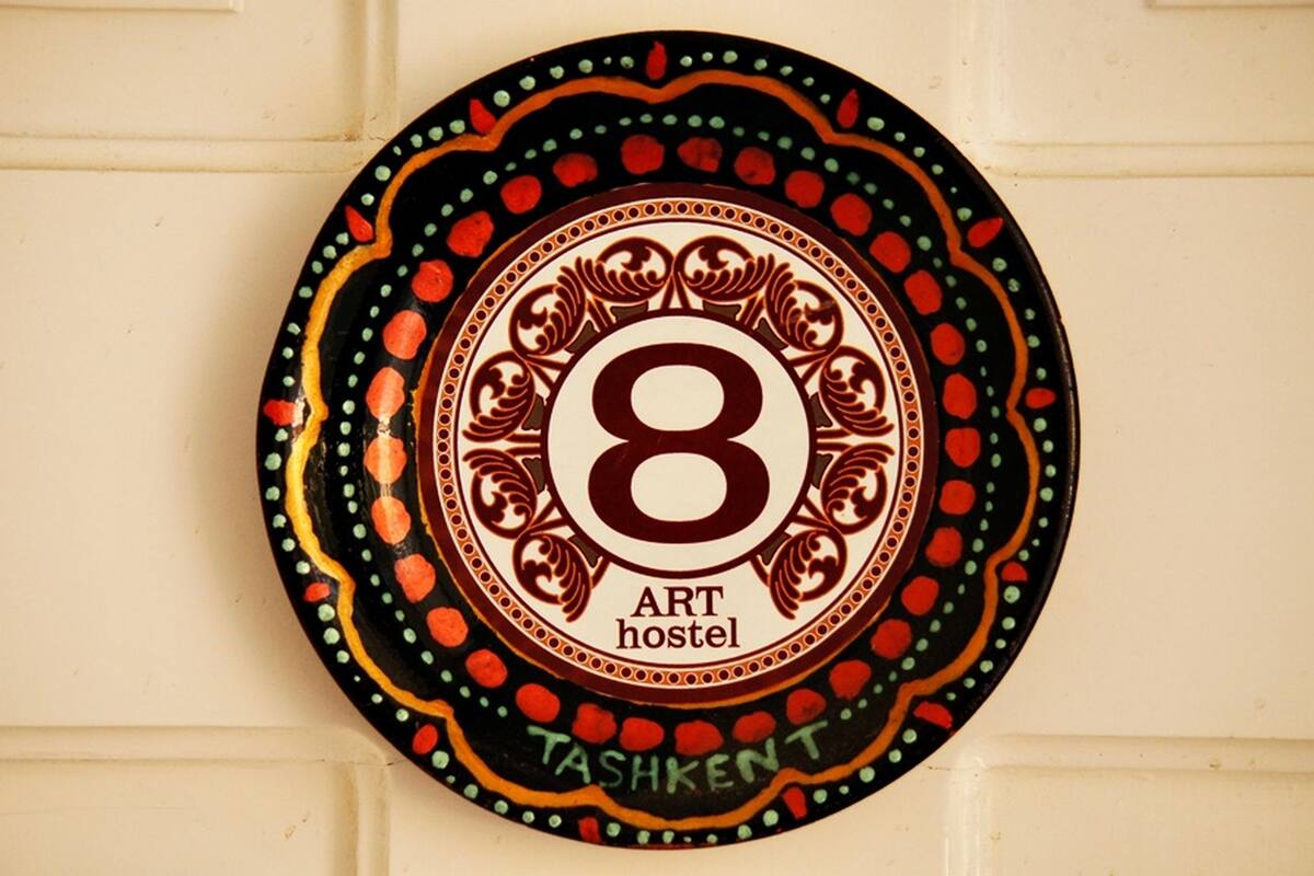 A circular sign with the number 8 and the words "ART hostel" and "TASHKENT" on it.