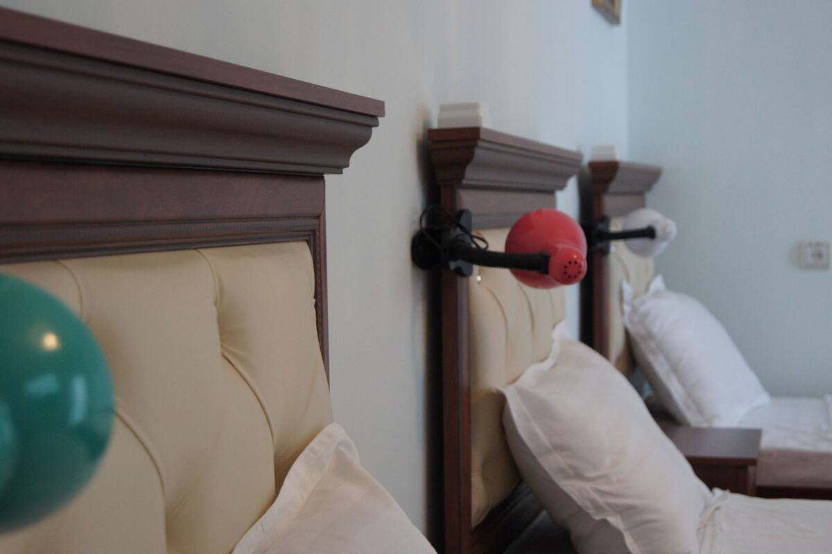 A bedroom with a wooden headboard, a bedside table, and a lamp.
