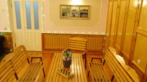 A dining area with wooden benches and a table, a door with frosted glass panels, and a wall-mounted picture.