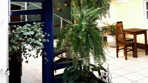 A blue spiral staircase with a wooden ceiling and a potted plant beside it. - Pousada Amendoeira (Búzios)