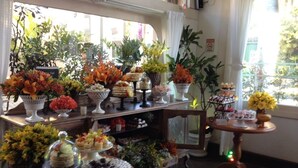A buffet table with various food items and floral decorations. - Pousada Amendoeira (Búzios)