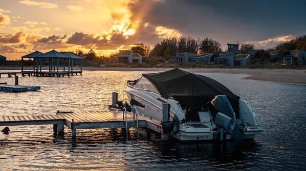 A boat docked at a pier with a sunset in the background.