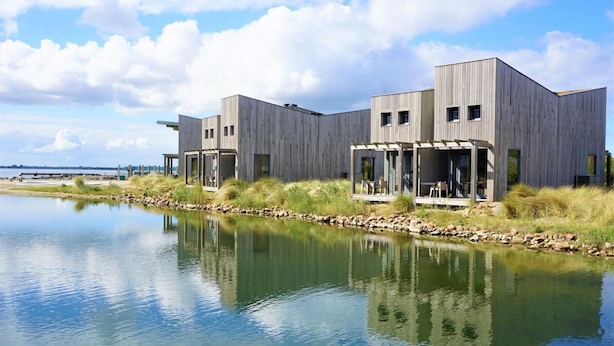 Un edificio moderno con techo plano, ventanas grandes y fachada uniforme.