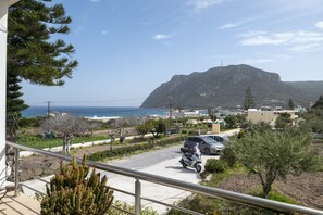 A coastal residential area with a view of the sea and a mountain in the background.