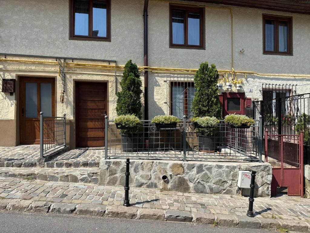 A building with a stone facade, wooden doors, and a metal gate.