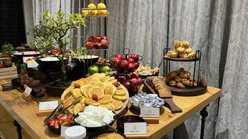 A buffet table with various food items including pancakes, whipped cream, and Nutella.