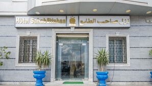 The exterior of Hotel Sahab Ettabaa with a modern entrance, decorative metal grilles, and potted plants. - Hotel Saheb Ettabaa (Tunis)