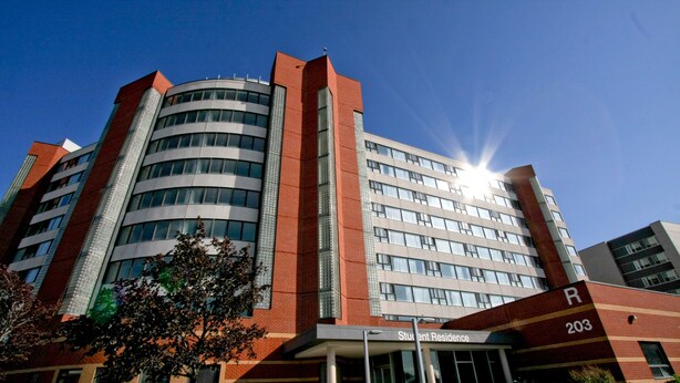 Un edificio de varios pisos con una entrada destacada que indica "Residencia Estudiantil 203".