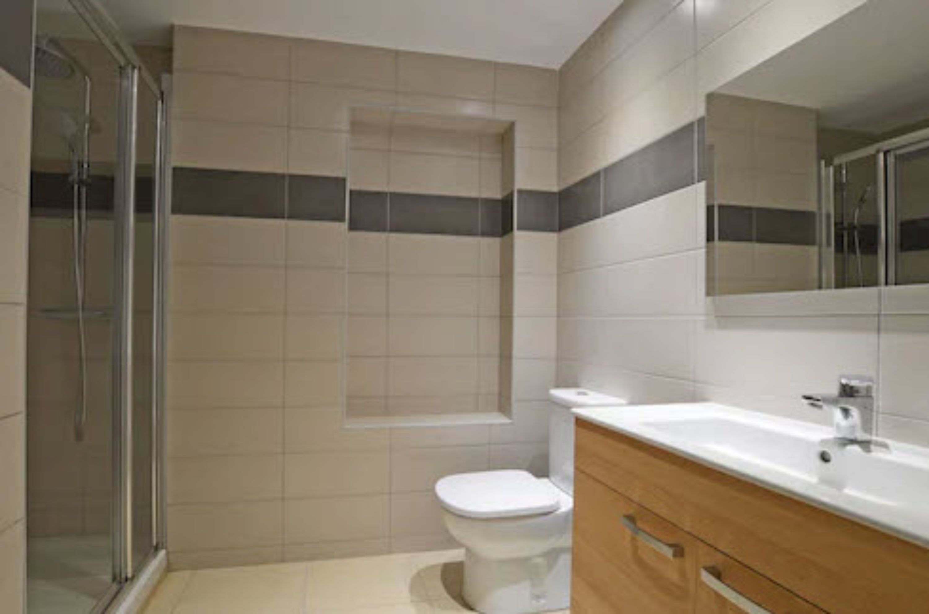 Un baño moderno con ducha, inodoro y tocador.