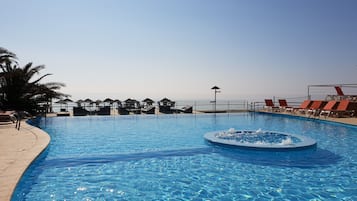 Piscine extérieure, parasols de plage, chaises longues