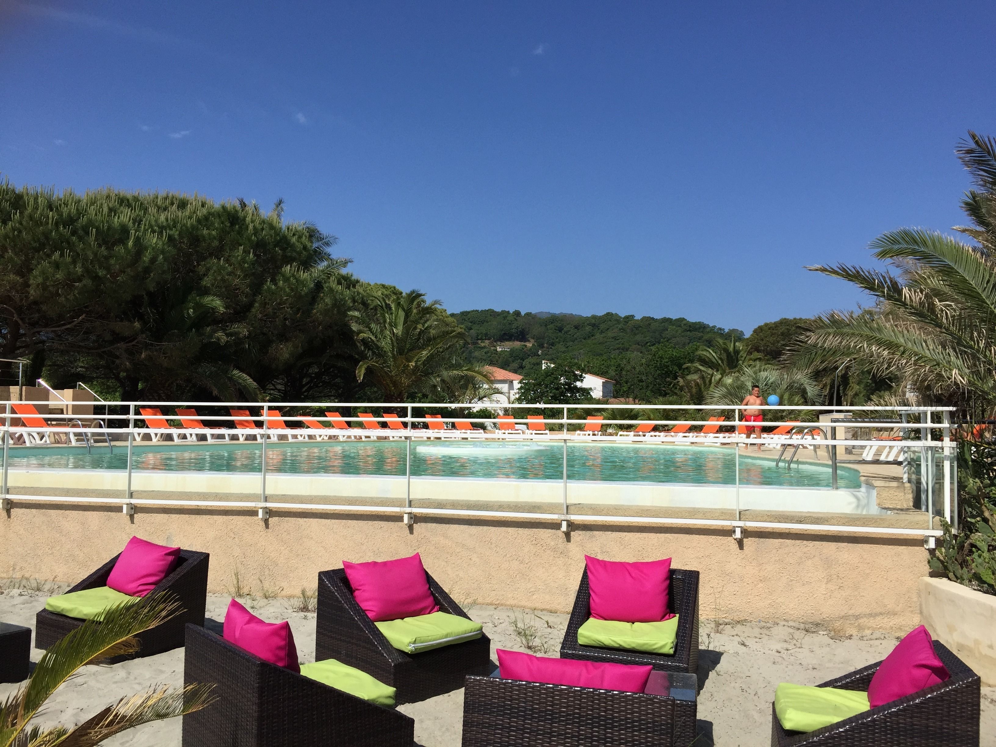 Zona de piscina con sillas de descanso y una piscina.