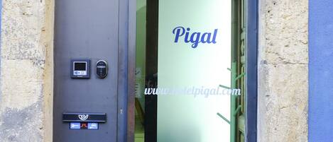 A hotel entrance with a digital keypad and a sign indicating 'Hotel - Residencia'.