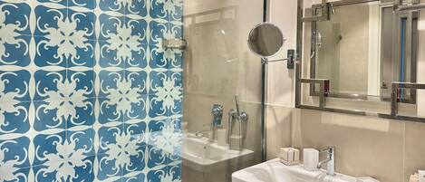 A bathroom with a shower, a sink, and a mirror.