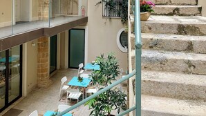 A multi-level courtyard with stone steps, outdoor seating, and potted plants. - Hotel San Michele (Trapani)