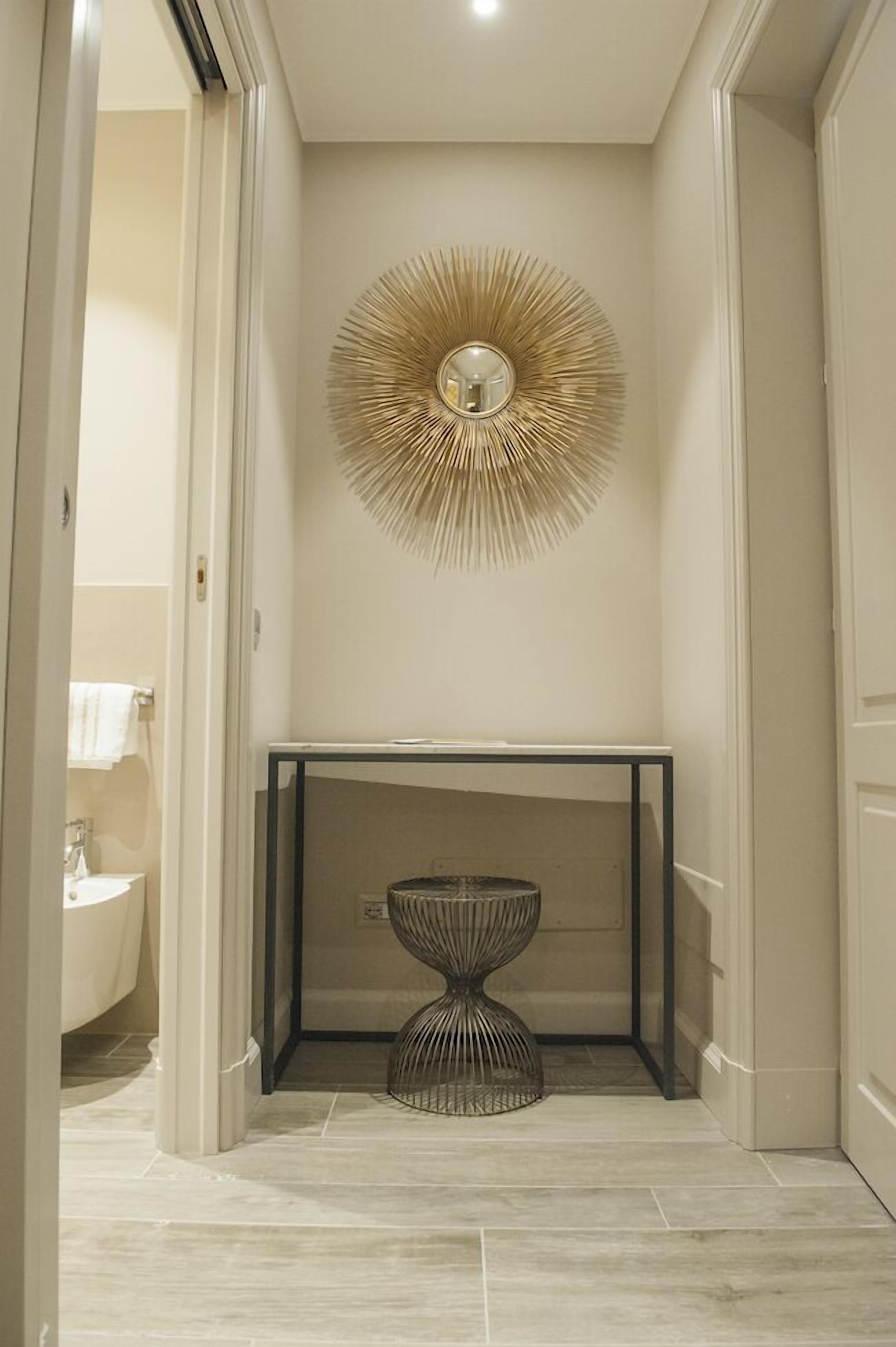 Un couloir agrémenté d’une décoration murale moderne et d’une table en métal.