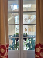 Una hall d'albergo moderna con una porta vetrata, una scala e piante da interno.