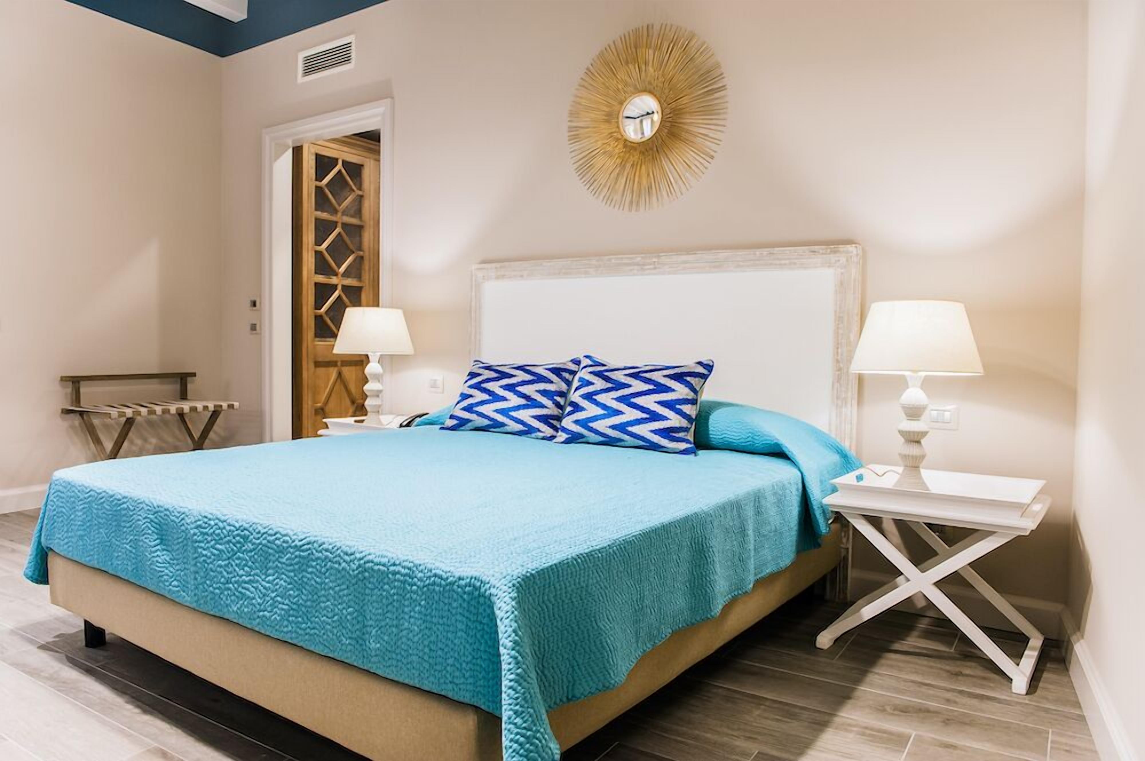 Un dormitorio con una cama, dos mesitas de noche, un reloj de pared y un adorno decorativo.