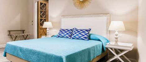 Un dormitorio con una cama, dos mesitas de noche, un reloj de pared y un adorno decorativo.