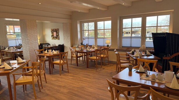 A spacious dining area with multiple tables and chairs, large windows with views, and a clean, modern interior. - Landhotel Franck (Brietlingen)