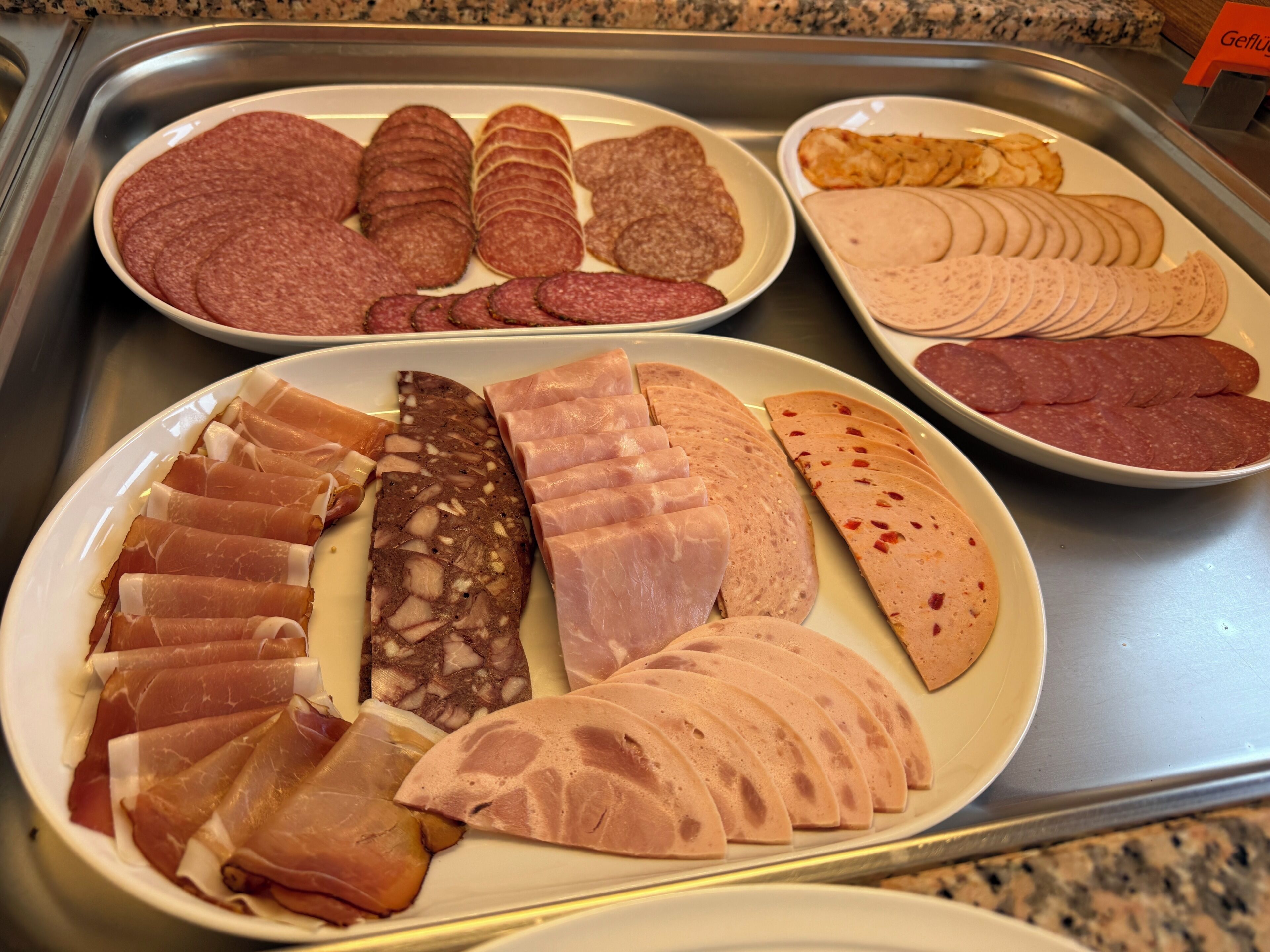 Diversas porciones de carne cortada presentadas en platos en una cocina.