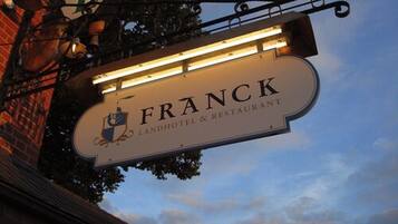 A sign for Franck Landhotel & Restaurant with a coat of arms emblem.