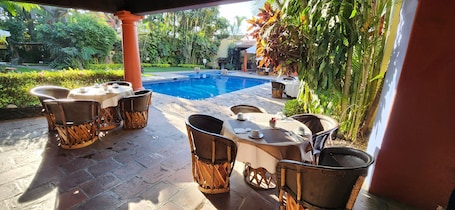 Una piscina al aire libre, sombrillas, sillones reclinables de piscina