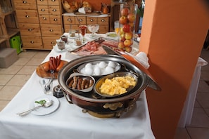 A breakfast buffet with various food items and utensils on a table. - Hotel & Restaurant Lindenhof (Bad Laasphe)