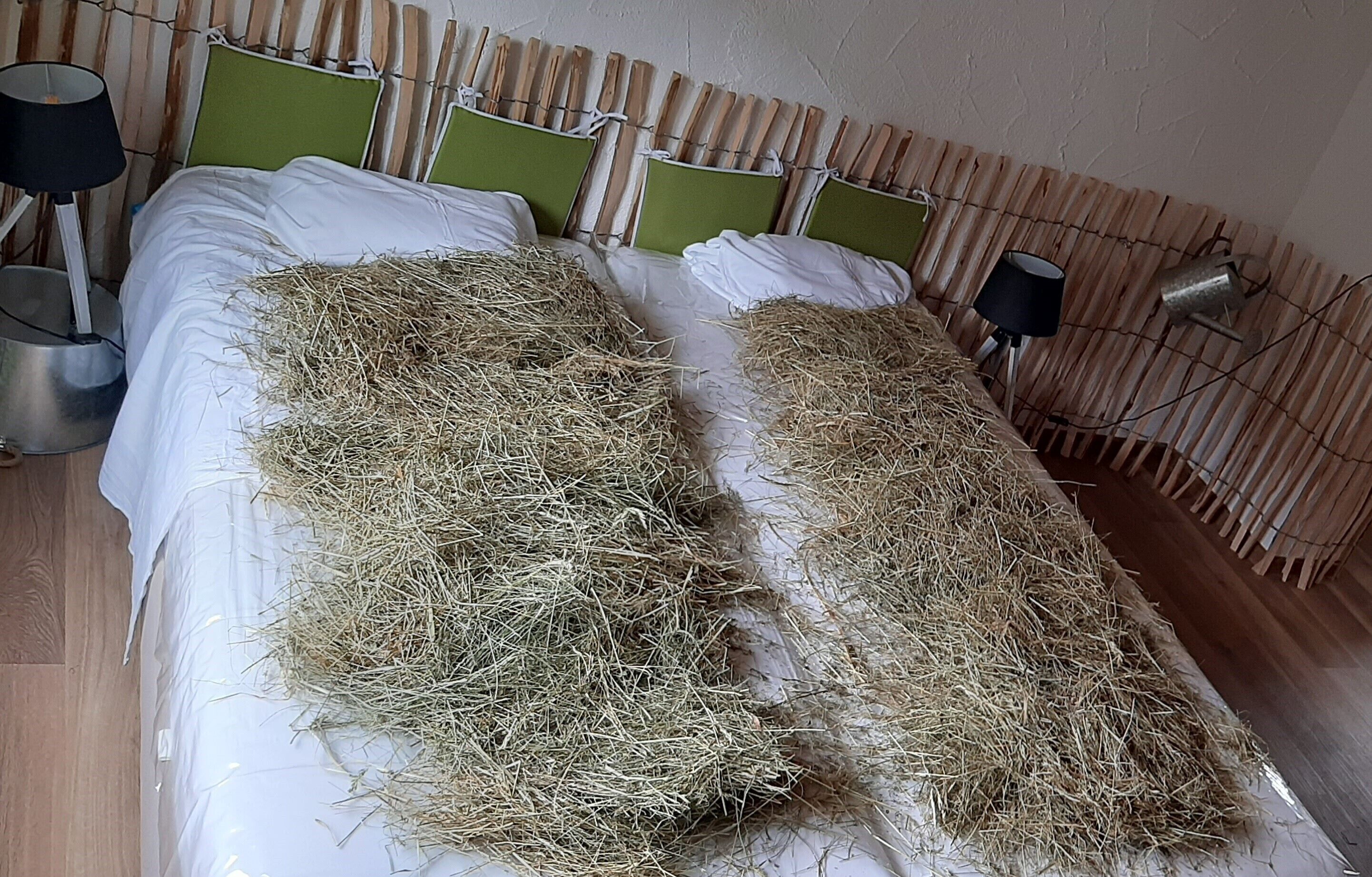 Una cama con ropa de paja y cabecera de bambú.