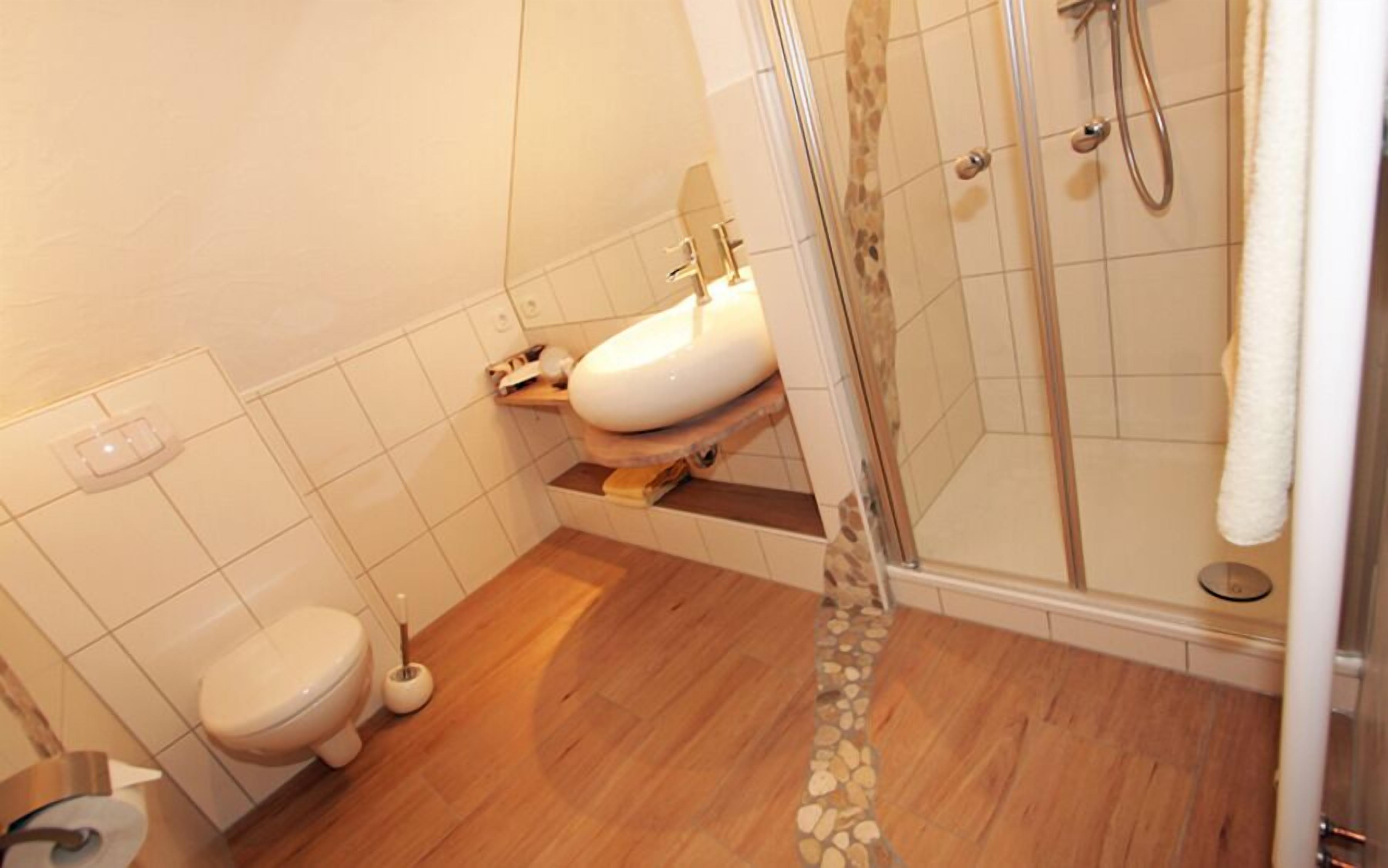 Un baño con inodoro, lavabo y ducha.