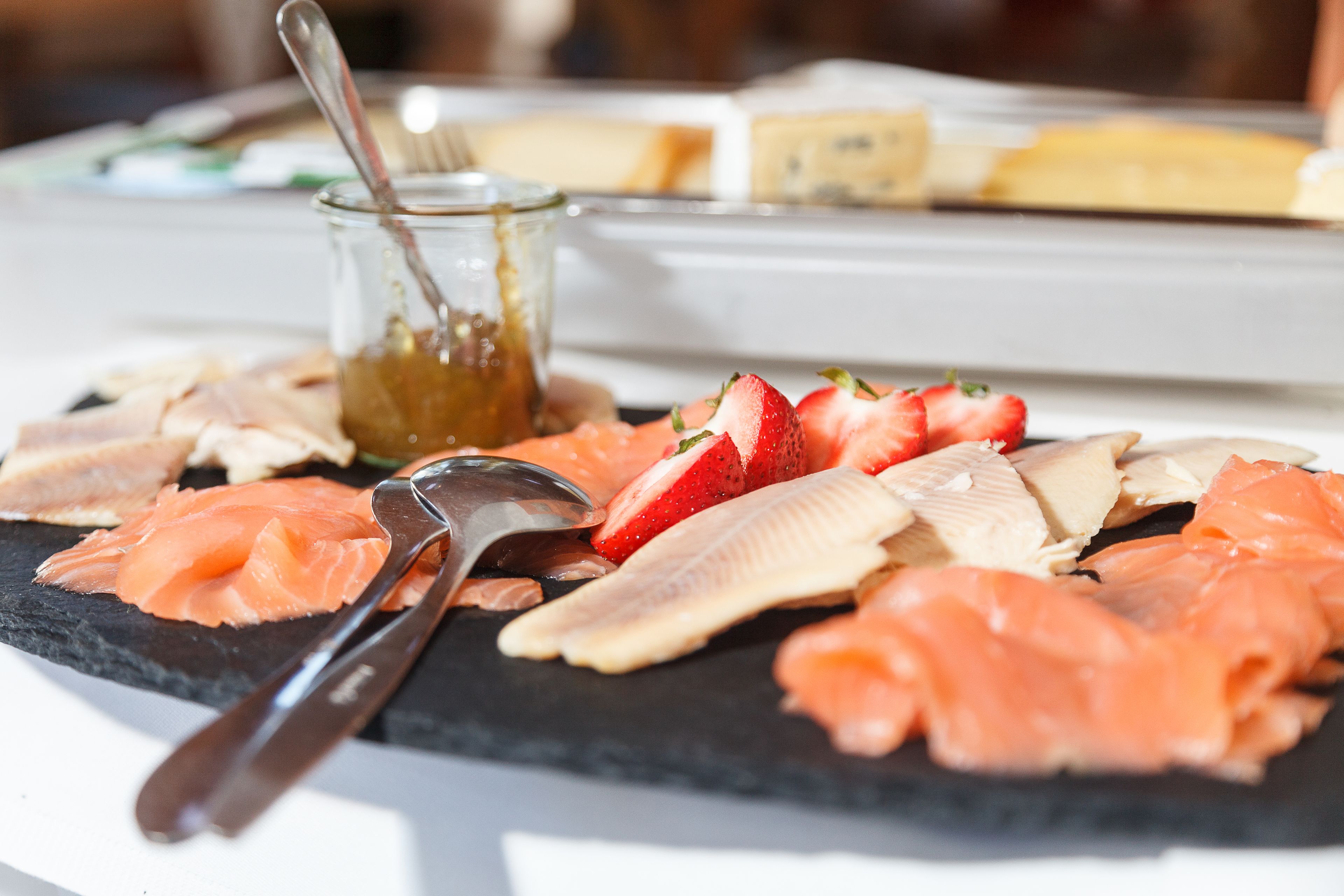 A charcuterie board with various meats and fruits.