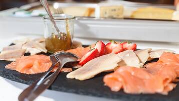 A charcuterie board with various meats and fruits.