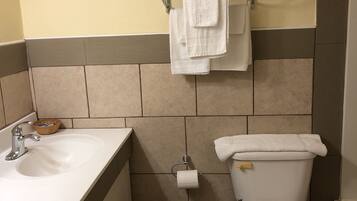 A bathroom with a sink, toilet, and a towel rack with towels.