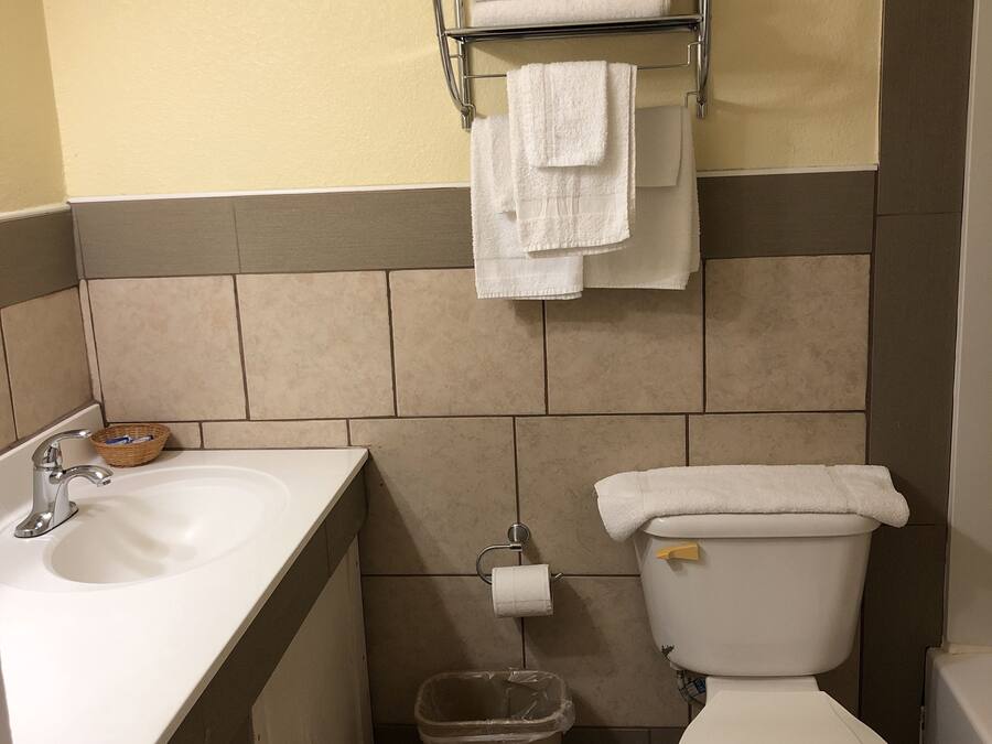 A bathroom with a sink, toilet, and a towel rack with towels.