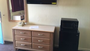 A hotel room with a flat-screen TV mounted on the wall, a minibar, a telephone, and a microwave. - Blarney Inn (Shamrock)