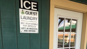 A door with a sign stating "ICE GUEST LAUNDRY NOT RESPONSIBLE FOR ARTICLES LEFT IN WASHERS AND DRYERS." - Blarney Inn (Shamrock)