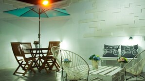 A dining area with a table and chairs, a hanging chair, and a wall-mounted bicycle decoration. - Hotel Karenina (Oaxaca)