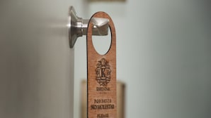 A wooden doorbell with a message in Spanish. - Hotel Karenina (Oaxaca)