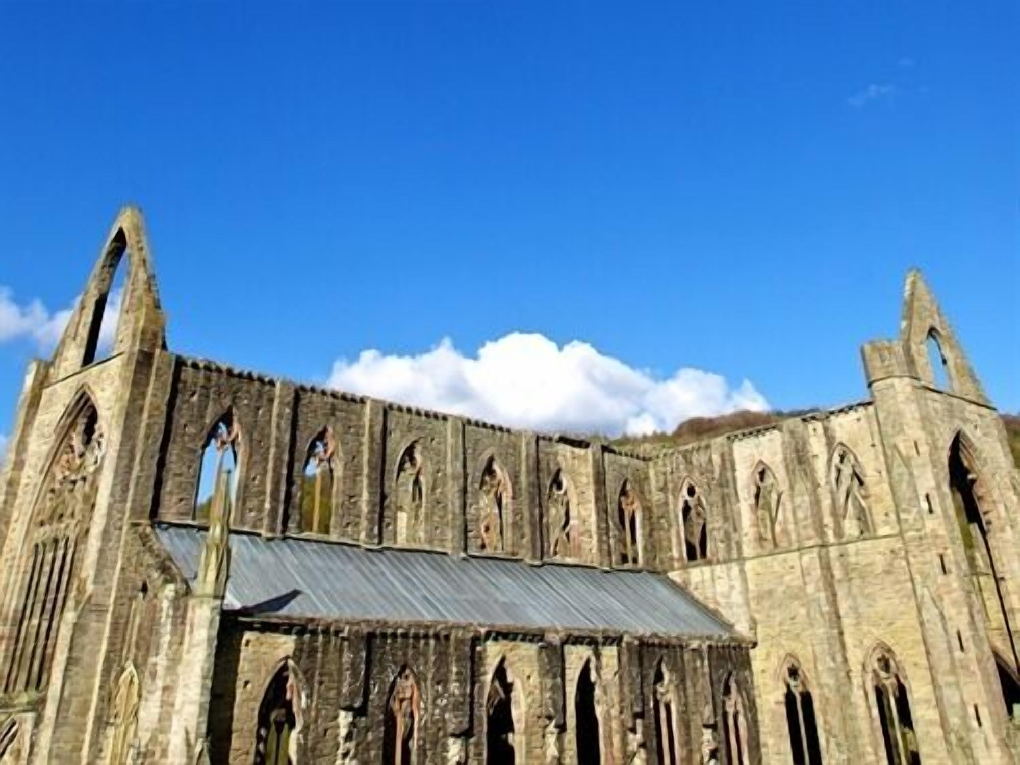 A historic stone building with multiple arched windows and a metal roof.