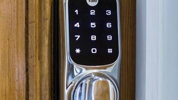 A Yale keypad lock on a wooden door.